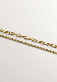 Tres cadenas de oro expuestas horizontalmente: una cadena de eslabones rectangulares planos, una cadena tradicional de eslabones redondos y una cadena más corta de eslabones trenzados.