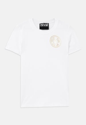 Hvit bomull t-skjorte med korte ermer og rund hals. Har et gullbrodert logo på brystet. Enkelt og klassisk design.