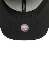 Gorra de béisbol negra con visera curvada, tela texturizada y una etiqueta circular que presenta un gráfico de béisbol con detalles debajo de la visera.