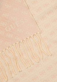 Svijetloružičasti šal napravljen od mekog materijala, s blagim utisnutim uzorkom i resicama na rubovima. Logo "GUESS" je vidljiv blizu ruba.