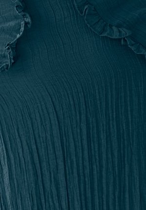 Gelaagd donkerblauwgroen stof met horizontale plooien en zachte gekruide randen, wat een gelaagd uiterlijk creëert. Geschikt voor casual of chique stijlen.