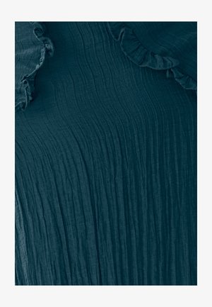 Gelaagd donkerblauwgroen stof met horizontale plooien en zachte gekruide randen, wat een gelaagd uiterlijk creëert. Geschikt voor casual of chique stijlen.