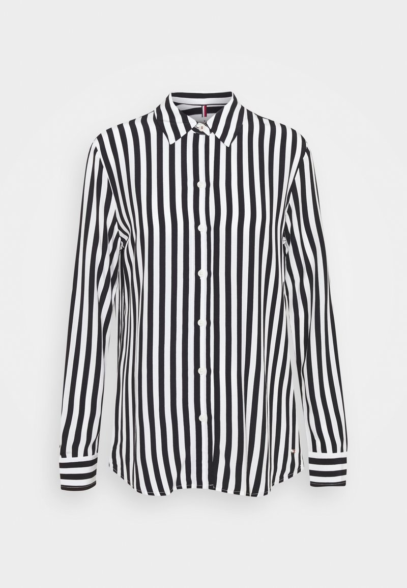 Camicia a maniche lunghe a righe bianche e nere con chiusura a bottoni e polsini a righe contrastanti. Realizzata in tessuto leggero.