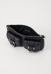 Svart lær crossbody-veske med glidelåslukking, to frontlommer, sølvfarget hardware, teksturert overflate og merkeinnvendig etikett.
