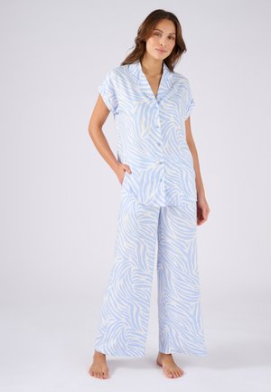Ensemble de pyjama bleu clair comprenant une chemise à manches courtes et un pantalon ample avec un motif à rayures blanches de zèbre. Tissu doux, coupe décontractée.