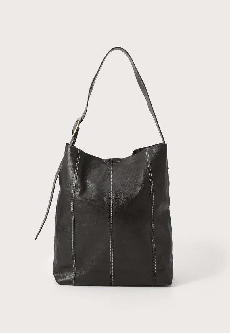 Svart skinn totebag med en myk tekstur, med to vertikale sømmer og et enkelt justerbart belte. Innvendig er den romslig og uten fôr.