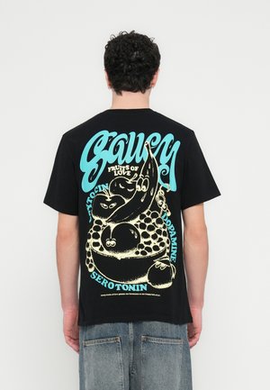 T-shirt en coton noir avec un motif graphique multicolore au dos, représentant des fruits et une typographie ludique. Manches courtes, coupe décontractée.