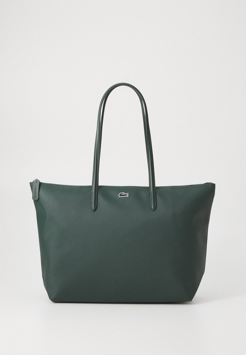 Sac cabas vert foncé avec longues poignées, surface texturée, fermeture éclair et petit logo blanc de crocodile au centre devant.