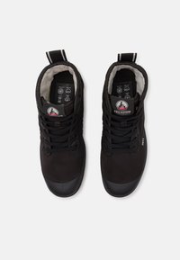 Sneaker nere alte in tessuto liscio, con punta in gomma, lacci rotondi e una linguetta. L'interno presenta una fodera imbottita e un logo.