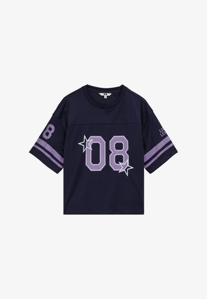 Tamsiai mėlynas trumpomis rankovėmis sportinis marškinėlis su levandų spalvos juostelėmis ant rankovių, didelis „08“ ir žvaigždės priekyje bei „08“ ant kairės rankovės.