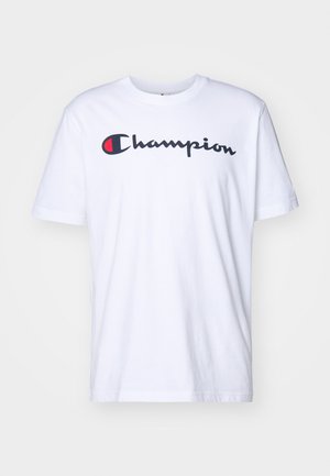 T-shirt bianco in cotone con maniche corte, caratterizzato da un prominente logo "Champion" in nero e rosso sul petto. Design semplice con collo a giro.