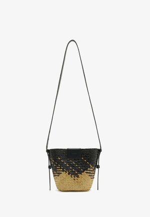 Bolso pequeño de estilo cesta tejido con colores negro y natural de paja, con una correa larga y delgada negra para el hombro y detalles de nudos laterales.