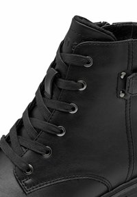 Schwarze Leder-Ankle-Boots mit abgerundetem Zehenbereich, Metallösen, flachen Schnürsenkeln und einer glatten Textur mit subtilen Steppnähten.