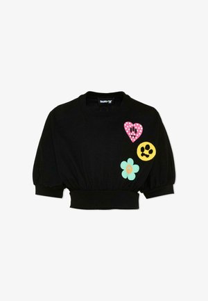 Sweat-shirt noir court avec manches bouffantes, orné sur le devant d'un cœur à pois roses, d'un visage souriant jaune et de patchs de fleurs vert menthe.