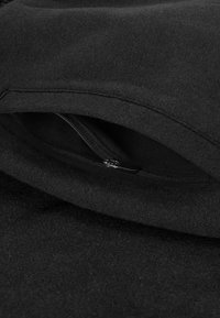 Zwarte hoodie met rits, met een gladde textuur en zachte stof, voorzien van een onopvallende ritstas die in het ontwerp is geïntegreerd.