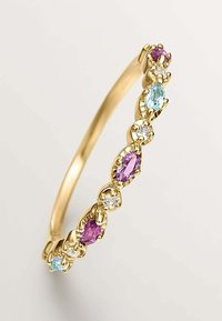 Anillo en tono dorado que presenta gemas alternas de color púrpura, azul y transparente con un corte facetado, montadas en un delicado diseño de garras.