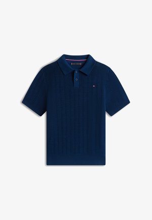 Marineblauw gebreid poloshirt met korte mouwen, textuurlijke verticale strepen en een sluiting met twee knopen. Klein rood, wit en blauw geborduurd logo op de borst.