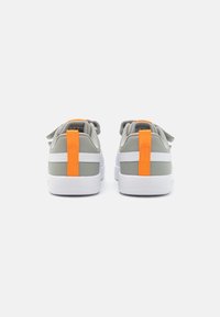 Baskets grises et blanches avec une tige texturée, dotées d'onglets de talon orange, de pointes arrondies et d'un design à lacets pour un maintien sûr.