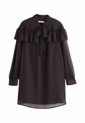 Sötétlila blúz magas nyakkal, fodros vállrész részletekkel, megkötős záródással és hosszú átlátszó ujjal. Lazán illeszkedő és ívelt szegéllyel készült.