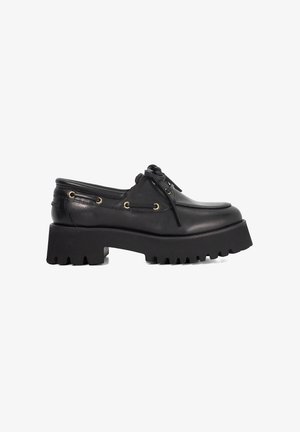 Black leather shoes with a rounded toe, thick platform sole, and side grommet detailing. Features laces and a smooth texture.
