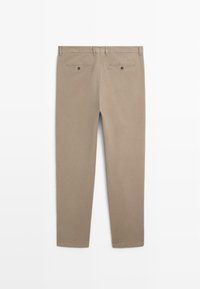 Beige Baumwollhose mit geradem Bein. Verfügt über zwei Gesäßtaschen mit Knöpfen und eine glatte Textur. Einfacher, schlichter Stil.