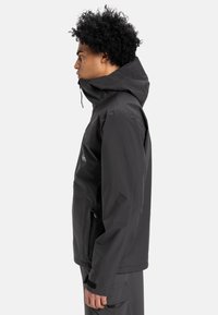 Black waterproof jacket with a high collar, adjustable hood, and zippered pockets. Features a sleek design and smooth texture.