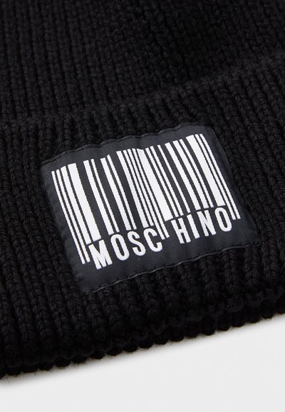Svart stickad mössa med ribbad textur. Har en vävd etikett som visar en vertikal streckkod och ordet "MOSCHINO" i vitt.