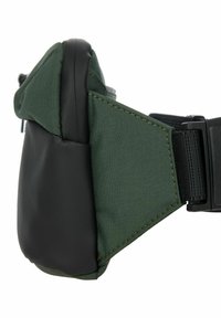 Pochette de taille en tissu vert avec un fond noir mat, présentant une finition texturée et une sangle ajustable pour un port sécurisé.