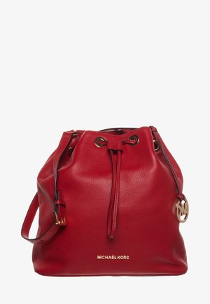Czerwona skórzana torba typu bucket z zapięciem na sznurek, regulowanym paskiem na ramię, złotym logo Michael Kors oraz okrągłą złotą zawieszką.