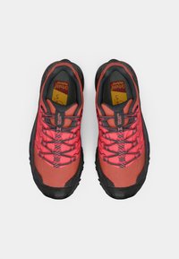 Κόκκινες και μαύρες αθλητικές παπουτσες για τρέξιμο σε μονοπάτια με πλέγμα στο πάνω μέρος, υφασμάτινο σύστημα κορδονιών, μαξιλαρωμένες σόλες και ανθεκτικές καουτσούκ σόλες.