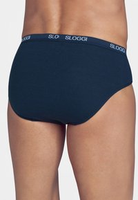 Mutande Sloggi blu navy con una texture morbida, caratterizzate da un cinturino con logo. Il taglio è a slip con una finitura liscia e senza cuciture visibili.