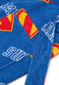 Asciugamano con cappuccio blu che presenta il logo di Superman in rosso e giallo con il testo "SUPERMAN" in bianco. Texture in spugna morbida, colori vivaci e design audace.