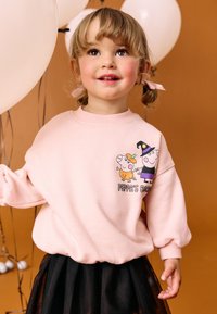 Ljusrosa sweatshirt med tryck av tecknade figurer på framsidan, rund halsringning och ribbade muddar, kombinerad med en svart tyllkjol.