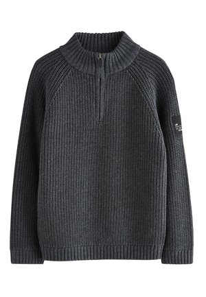 Grå strikket sweater med høj krave og halvlukning med lynlås. Ribbet tekstur med lange ærmer og et mærke på venstre arm.