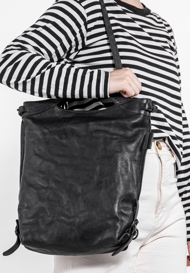 Schwarze Lederhandtasche mit strukturiertem Oberflächen, oberen Griffen und verstellbarem Schultergurt. Verfügt über eine einfache, rechteckige Form und minimalen Beschlag.