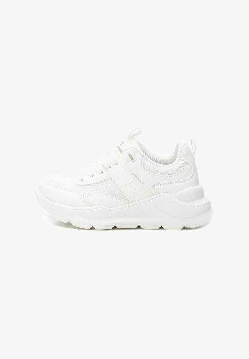 Zapatilla blanca con empeine de tela texturizada, cuello acolchado y suela de goma gruesa. Presenta cordones y un tacón plano para un soporte estable.