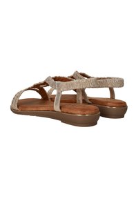 Lichtgouden sandalen met textuurlussen en een gewatteerde bruine binnenzool. Beschikt over een lage platform en T-bar ontwerp voor ondersteuning.