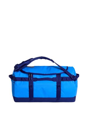 Grande borsa da viaggio blu e blu navy con tracolla regolabile, più maniglie, scomparto principale con zip e cinghie anteriori con fibbie su sfondo bianco.