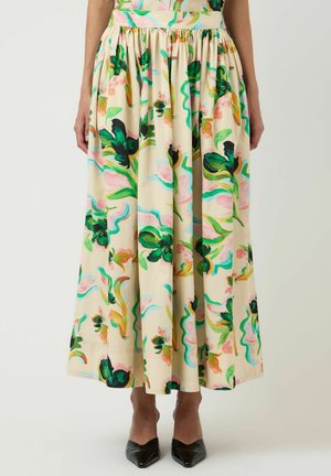 Kremfarget midiskjørt med grønt og rosa blomsterprint, rynket midje, brukt med svarte spisse sko og en matchende blomster-topp.