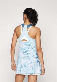 Világoskék sportruha, textúrált akvarell mintával, versenyhátra hajtott kialakítással és kivágott részlettel a háton, fodros szoknyával.