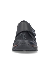 Chaussure noire texturée avec large bride réglable et bout arrondi, vue de face sur fond blanc.