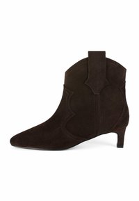 Stivale alla caviglia in suede marrone con punta allungata, ritagli decorativi, tacco corto e una linguetta sul retro. Presenta dettagli di cuciture a contrasto.