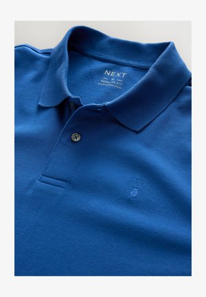 Zils polo krekls, izgatavots no teksturēta auduma, ar apkakli, divu pogu atdali un izšūtu staltbrieža logo uz kreisā krūšu kabata.