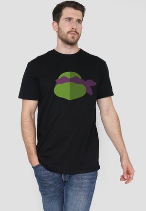 Schwarzes Baumwoll-T-Shirt mit einem grünen und lila Grafikdesign auf der Vorderseite, das eine Charaktermaske darstellt. Klassischer Schnitt mit kurzen Ärmeln.
