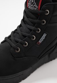 Svarta högskurna sneakers med texturerat läder och mesh-detaljer, runda metallhål och Kappa-logotyp. Har en tjock gummisula för bra grepp.