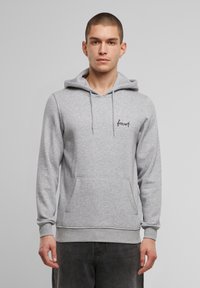 Felpa grigia realizzata in tessuto misto cotone. Presenta una tasca frontale, cappuccio con cordino e logo "forest" ricamato sul petto.