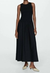Robe noire sans manches avec un corsage ajusté et une jupe froncée, fabriquée en tissu lisse ; longueur genou et design fluide, style minimaliste.