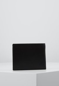 Portofel din piele neagră cu o textură netedă, formă rectangulară și un design minimalist. Fără elemente de feronerie sau accente vizibile.