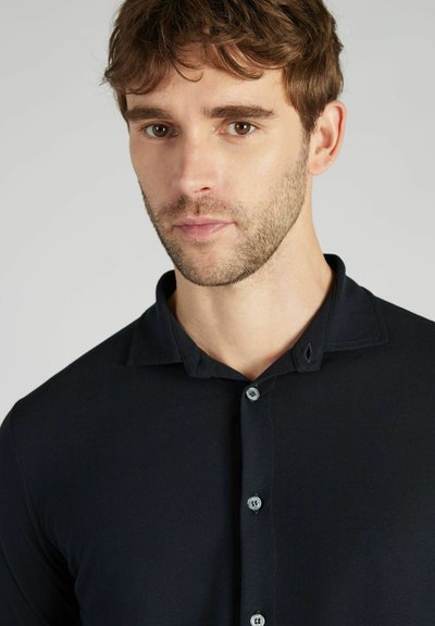 Polo shirt navy a maniche corte con colletto a camicia, caratterizzato da una texture liscia e bottoni azzurri lungo la patta.