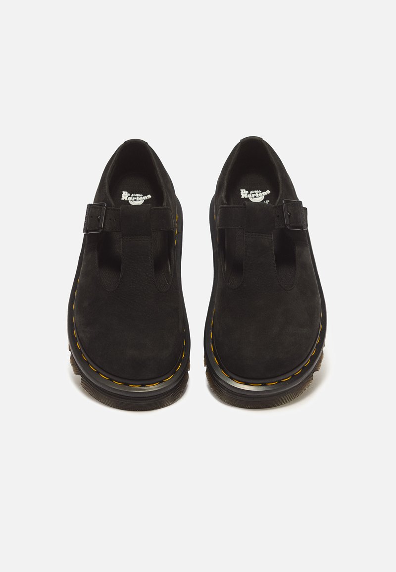 Pair of black suede T-bar shoes with yellow stitching and buckle strap, viewed from above against a white background.
